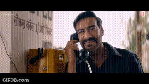A Man Is Talking On A Yellow Pay Phone GIF