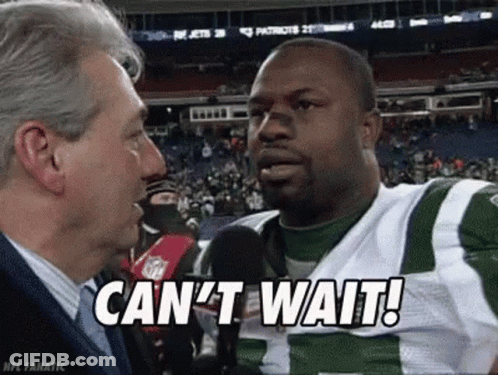 A Man Is Talking To A Football Player Who Is Wearing A Green And White Uniform . GIF