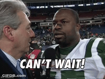 A Man Is Talking To A Football Player Who Is Wearing A Green And White Uniform . GIF