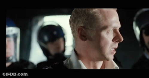 A Man Is Talking To A Group Of Police Officers In Riot Gear . GIF
