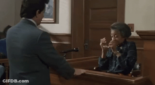 A Man Is Talking To A Woman In A Courtroom . GIF