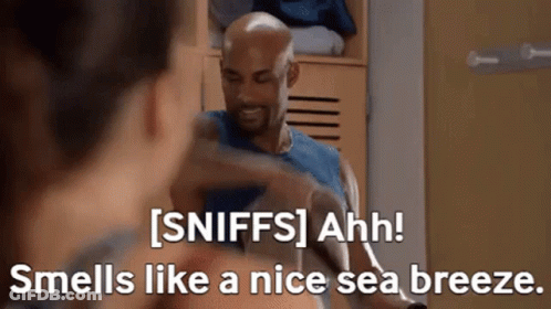 A Man Is Talking To A Woman In A Locker Room And The Woman Is Smelling Like A Nice Sea Breeze GIF