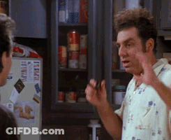 A Man Is Talking To Another Man In A Kitchen With A Refrigerator That Says Item On It . GIF