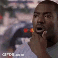 A Man Is Thinking With His Hand On His Chin . GIF