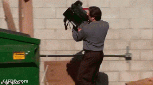 A Man Is Throwing A Backpack Into A Dumpster .. GIF