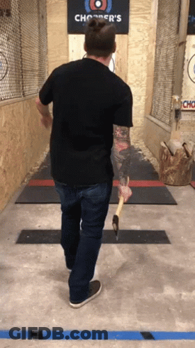 A Man Is Throwing An Axe At A Chopper 'S Sign GIF