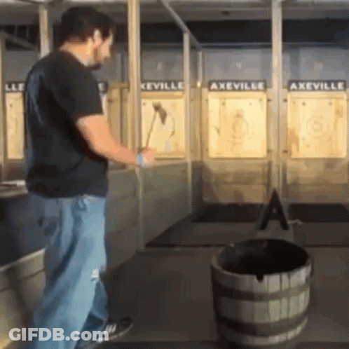 A Man Is Throwing An Axe At A Target In A Axeville GIF