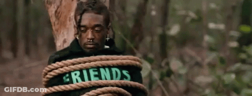 A Man Is Tied To A Tree Trunk With A Rope . GIF