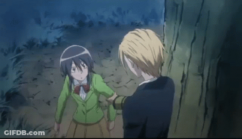 A Man Is Touching A Girl 'S Face While They Are Standing Next To Each Other In A Forest . GIF