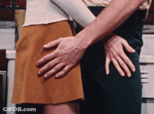 A Man Is Touching A Woman 'S Butt With His Hand GIF
