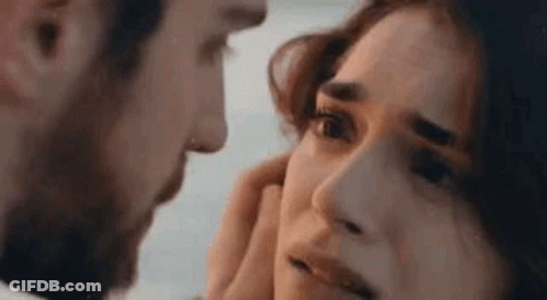 A Man Is Touching A Woman 'S Face With His Hand . GIF