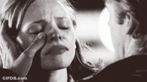 A Man Is Touching A Woman 'S Face With His Hand . GIF