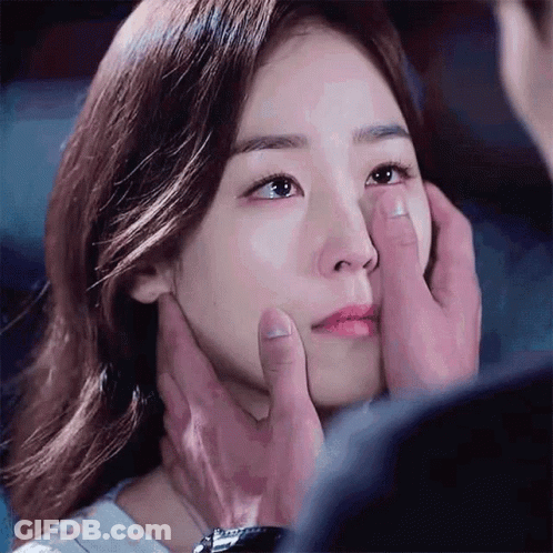 A Man Is Touching A Woman 'S Face With His Hands GIF
