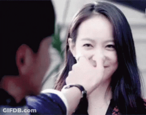 A Man Is Touching A Woman 'S Nose While She Smiles GIF