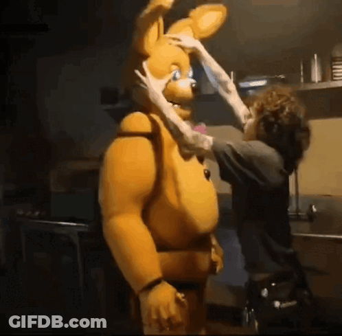 A Man Is Touching The Face Of A Stuffed Animal GIF