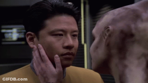 A Man Is Touching The Face Of Another Man GIF