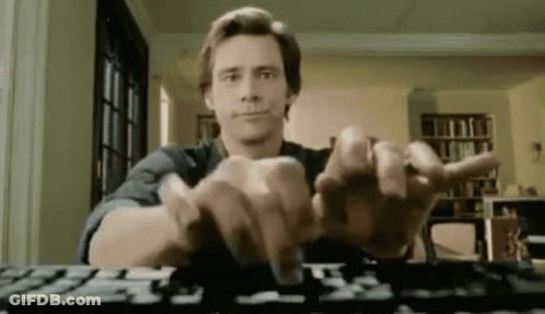 A Man Is Typing On A Computer Keyboard While Sitting At A Table . GIF