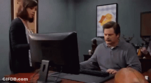 A Man Is Using A Computer While A Woman Looks On GIF