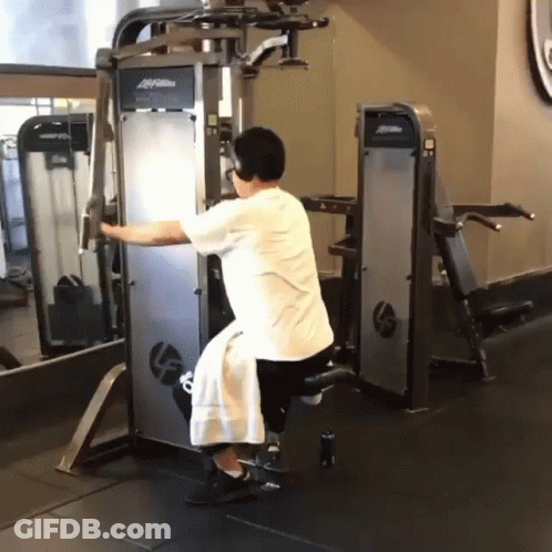 A Man Is Using A Machine With The Word Life Fitness On It GIF