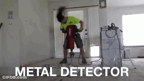 A Man Is Using A Metal Detector To Drill A Hole In A Wall GIF