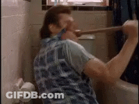 A Man Is Using A Plunger To Clean A Toilet . GIF