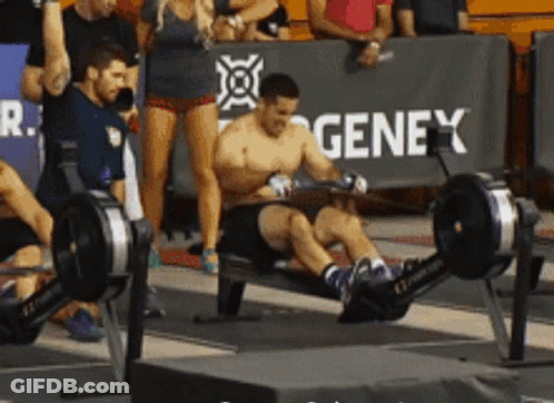 A Man Is Using A Rowing Machine In Front Of A Genex Sign GIF