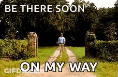 A Man Is Walking Down A Dirt Road With The Words `` Be There Soon On My Way '' Above Him . GIF