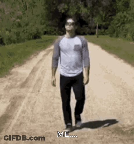 A Man Is Walking Down A Dirt Road With The Words `` Me '' Written On The Ground . GIF