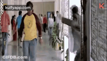 Man Walking Down Hallway With Group GIF