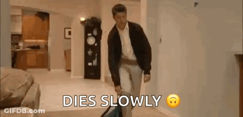 A Man Is Walking Down A Hallway With A Suitcase And The Words `` Dies Slowly '' . GIF