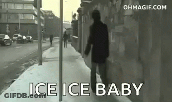 A Man Is Walking Down A Snowy Sidewalk With The Words `` Ice Ice Baby '' Written On The Sidewalk . GIF