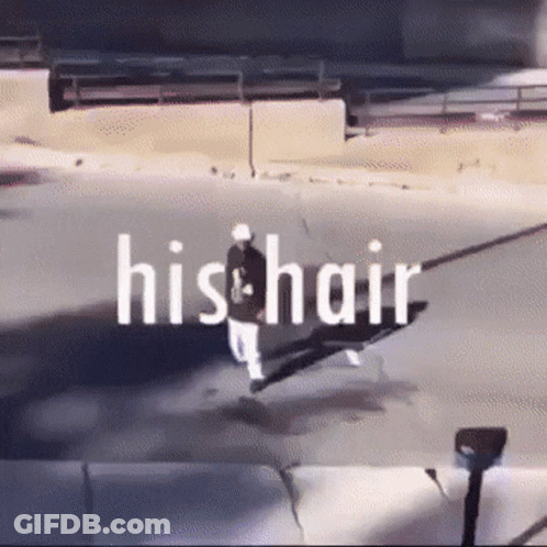 A Man Is Walking Down A Street With The Words His Hair Written Above Him GIF