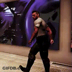 A Man Is Walking In Front Of A Purple Wall GIF
