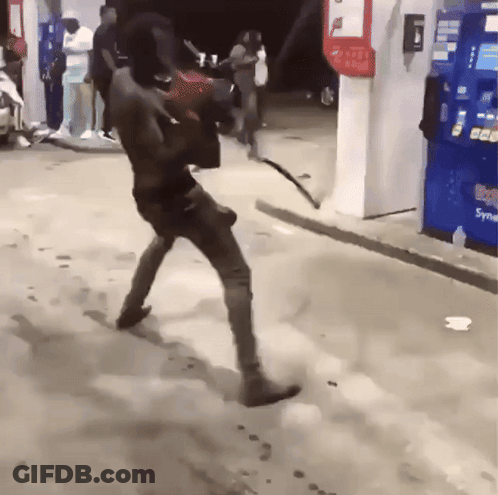 A Man Is Walking In Front Of A Vending Machine That Says Soda GIF