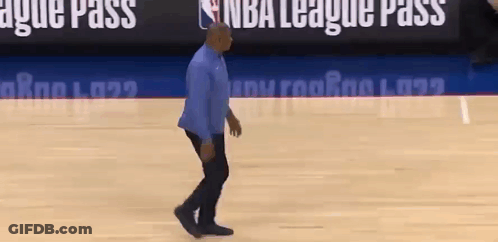 A Man Is Walking On A Basketball Court In Front Of A Nba League Pass Sign . GIF