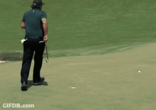 A Man Is Walking On A Golf Course With A Golf Club In His Pocket GIF