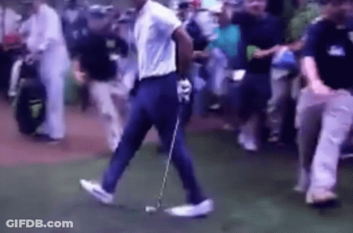 A Man Is Walking On A Golf Course With A Golf Club GIF
