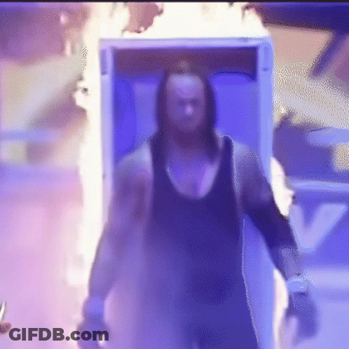 A Man Is Walking Out Of A Box With Flames Coming Out Of It And Holding A Knife . GIF