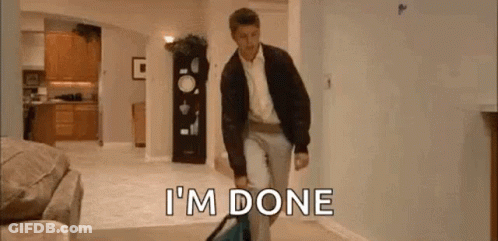 A Man Is Walking Through A Living Room Carrying A Suitcase And A Bag . GIF
