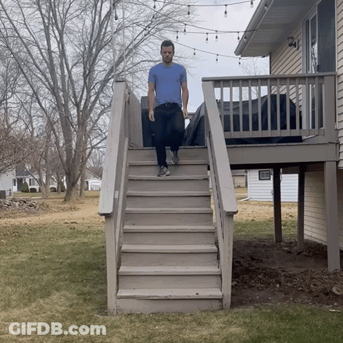 A Man Is Walking Up A Set Of Stairs GIF