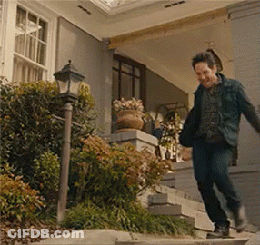 A Man Is Walking Up The Stairs Of A House . GIF