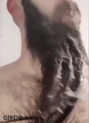 A Man Is Washing His Hair In A Bathtub With Water Coming Out Of His Head . GIF