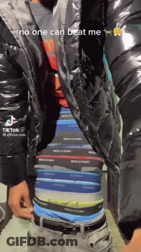 A Man Is Wearing A Black Jacket And Underwear That Says No One Can Beat Me On It GIF