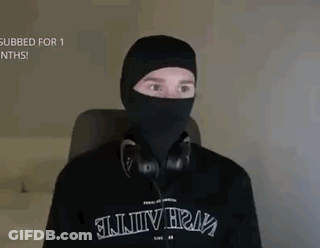 A Man Is Wearing A Black Mask And Headphones While Sitting In A Chair . GIF