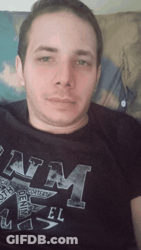 A Man Is Wearing A Black Shirt That Says Denim On It GIF