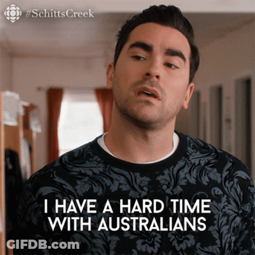 A Man Is Wearing A Black Shirt That Says I Have A Hard Time With Australians GIF