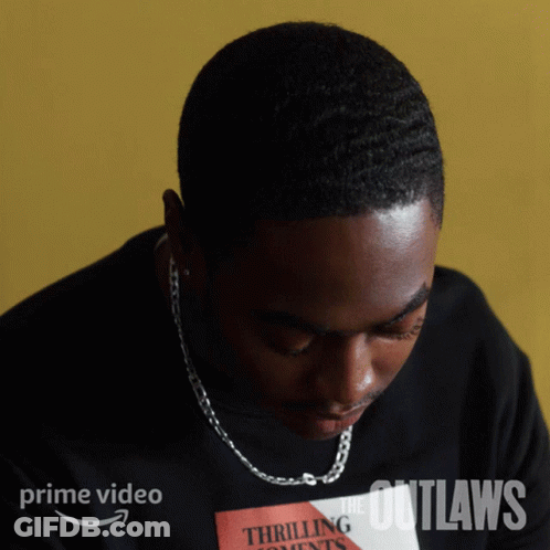 A Man Is Wearing A Black Shirt That Says The Outlaws On It GIF