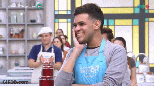 A Man Is Wearing A Blue Apron That Says Bake Off Argentina GIF