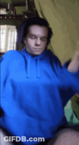 A Man Is Wearing A Blue Hoodie And Headphones GIF