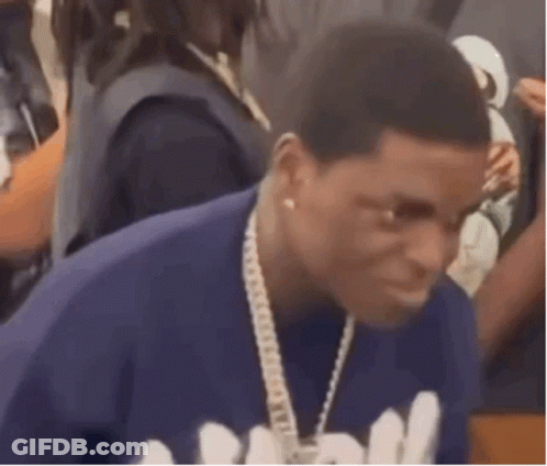A Man Is Wearing A Blue Shirt And A Chain Around His Neck . GIF